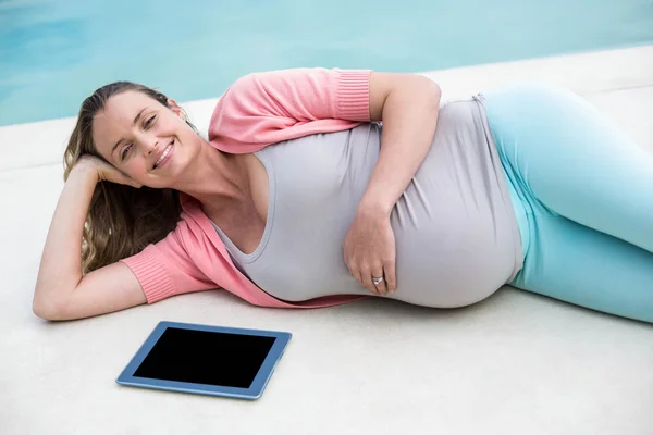 Gravid kvinna avkopplande utanför använder tablet — Stockfoto