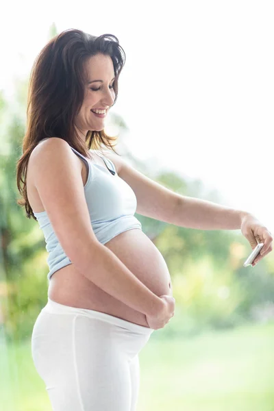 Pregnant woman taking a picture — Stock Photo, Image