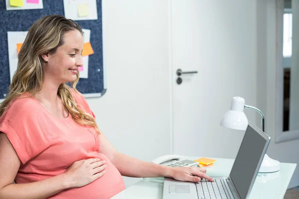 Mulher grávida usando laptop — Fotografia de Stock