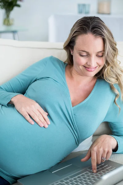 Hamile kadın bir dizüstü bilgisayar kullanarak — Stok fotoğraf