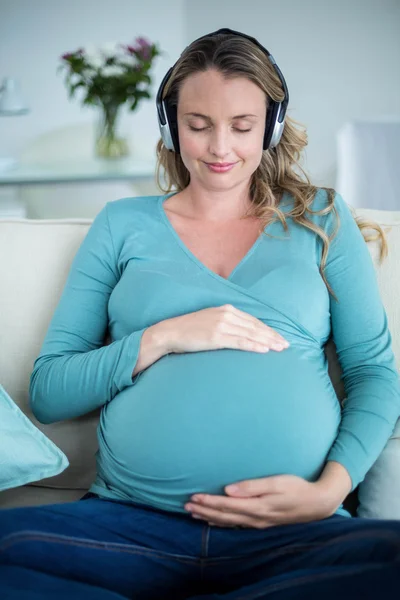 Zwangere vrouw luisteren naar muziek — Stockfoto