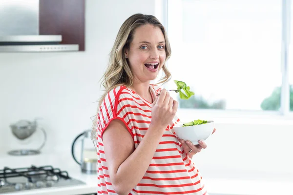 Mulher grávida comendo uma tigela de salada — Fotografia de Stock