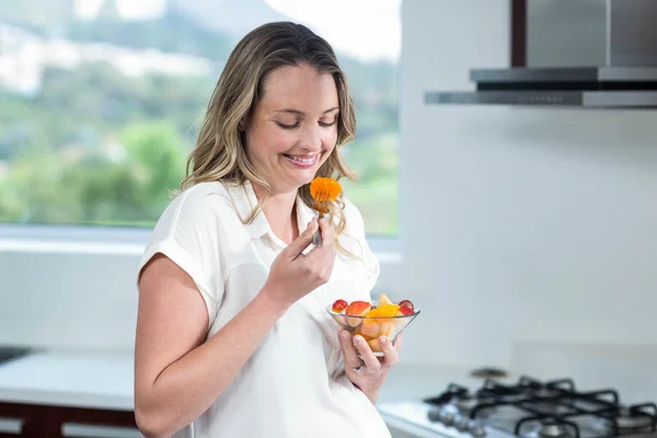 Mujer embarazada comiendo ensalada de frutas — Foto de Stock