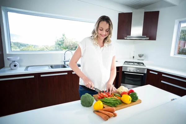 Mulher grávida cortando legumes — Fotografia de Stock