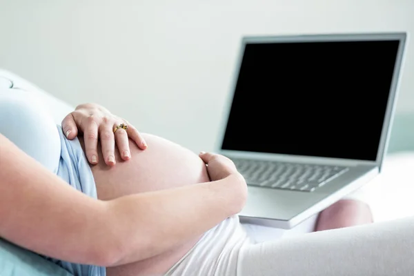 Donna incinta utilizzando il computer portatile — Foto Stock