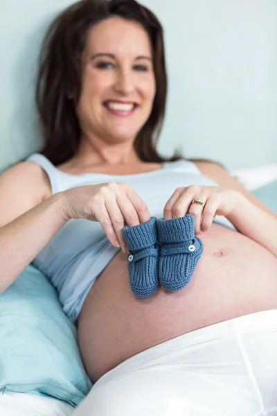 Femme enceinte avec des pantoufles tricotées — Photo