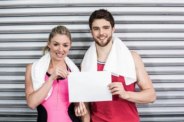 Fit casal segurando papel em branco — Fotografia de Stock