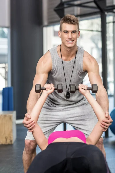 Entrenador masculino que ayuda a la mujer a levantar pesas — Foto de Stock