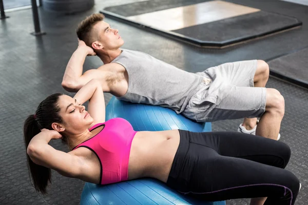 Ajuste pareja haciendo abdominales crujidos — Foto de Stock