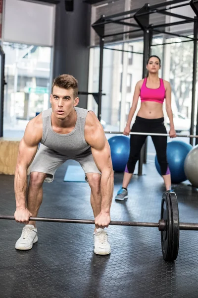 Fit couple lifting barbell — Stock Photo, Image