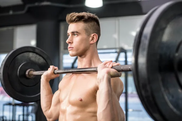 Homem apto levantando barbell — Fotografia de Stock