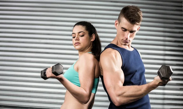 Fitte Menschen, die Hanteln nach hinten heben — Stockfoto