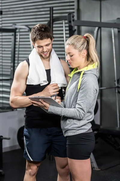 Smiling fit couple taking notes — Stock Photo, Image