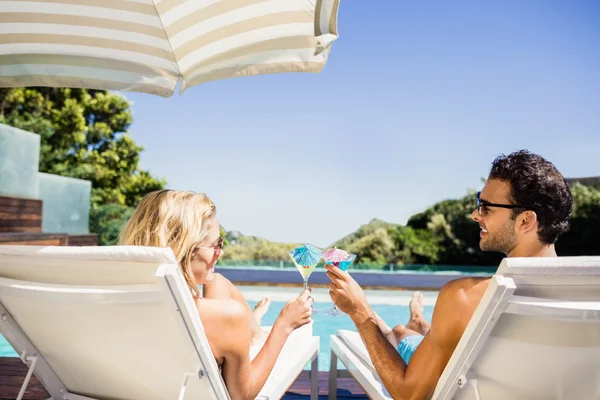 Happy couple on deck chair holding cocktails — Stock Photo, Image