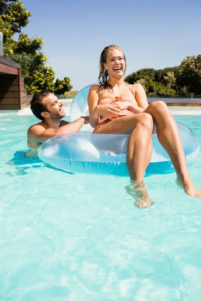 Happy couple in the pool with lilo — Stock Photo, Image