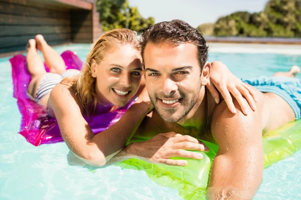 Happy couple with lilos in the pool — Stock Photo, Image