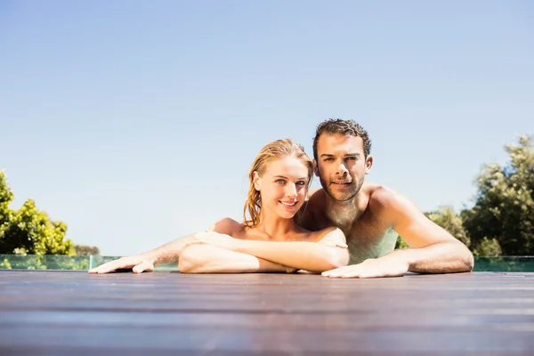 Couple heureux penché sur le bord de la piscine — Photo