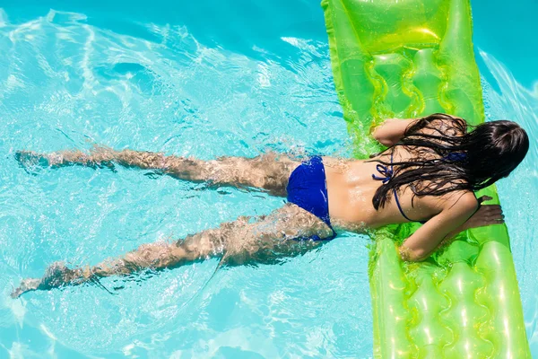 Woman in the pool holding lilo — Stock Photo, Image