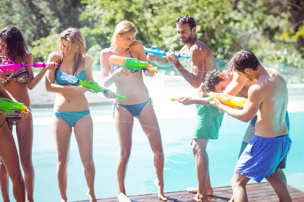 Happy friends doing water gun battle — Stock Photo, Image