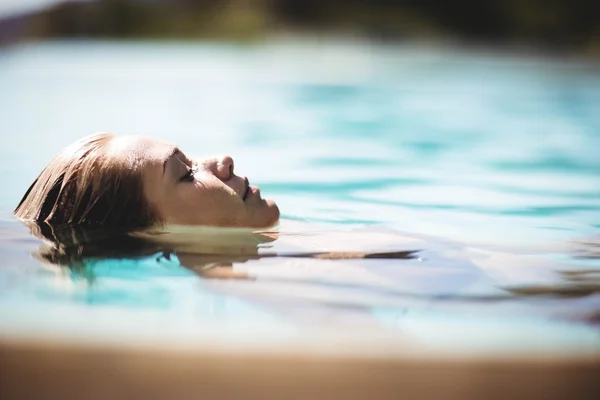 Fredlig blondin flytande i poolen — Stockfoto