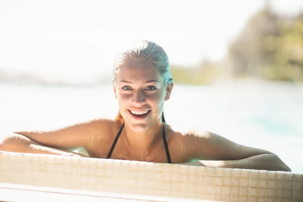 Porträt einer lächelnden Blondine im Pool — Stockfoto