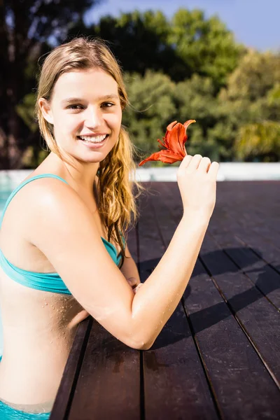 Sonriente rubia sosteniendo flor roja — Foto de Stock