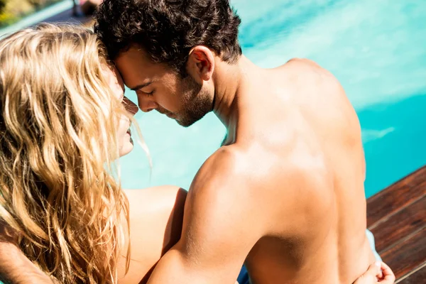 Rear view of couple sitting by the pool — Stock Photo, Image