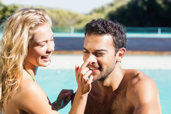 Girlfriend applying cream to boyfriend — Stock Photo, Image