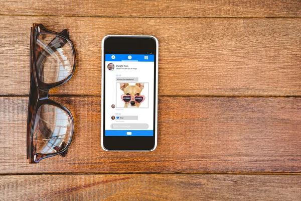メガネとテーブルの上のスマート フォン — ストック写真