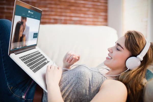 Kvinna med sin laptop med hörlurar — Stockfoto