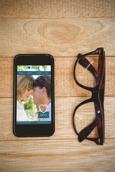 Gözlük ve masada bir akıllı telefon — Stok fotoğraf