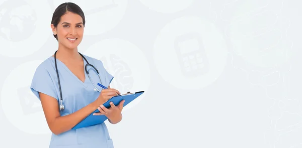 Smiling nurse writing against beige — Stock Photo, Image