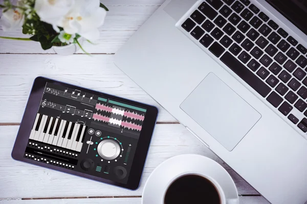 Music app against tablet on desk — Stock Photo, Image