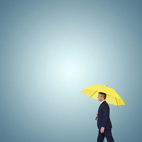 Empresario con paraguas amarillo caminando — Foto de Stock