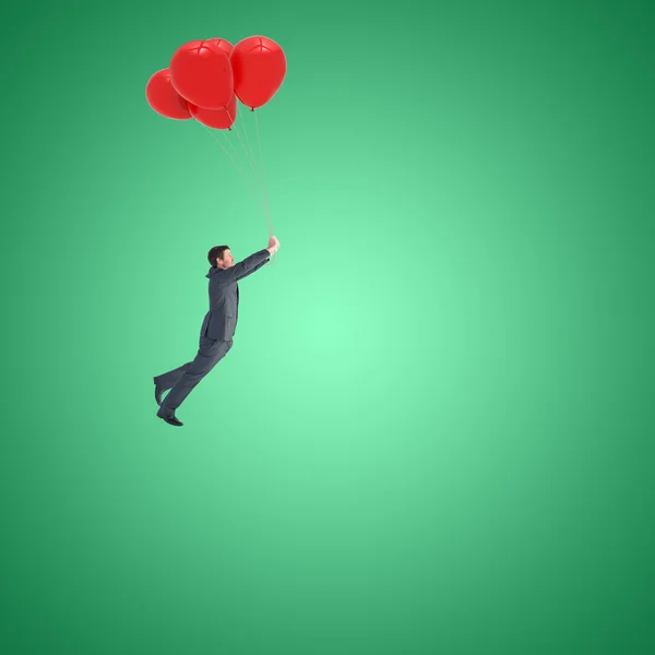 Uomo d'affari che vola con palloncini — Foto Stock