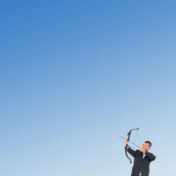 Businessman shooting a bow and arrow — Stock Photo, Image