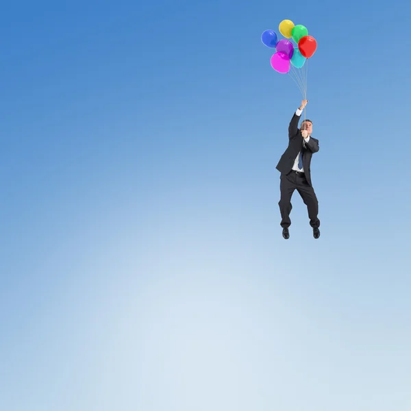 Empresario volando con globos —  Fotos de Stock