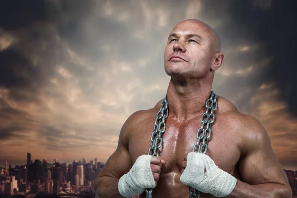 Confident bodybuilder holding chain — Stock Photo, Image