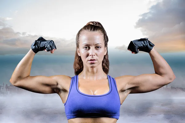 Mujer con guantes flexionar los músculos — Foto de Stock