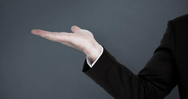 Businessman presenting against grey — Stock Photo, Image