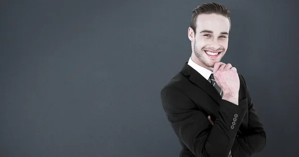 Empresario de pie con la mano en la barbilla — Foto de Stock