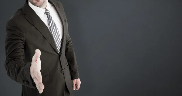 Businessman smiling and offering hand — Stock Photo, Image