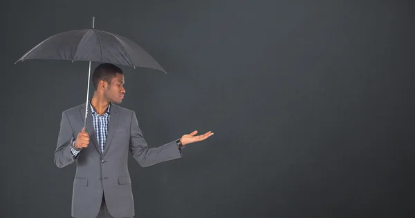 Businessman standing under umbrella — Stock Photo, Image