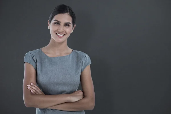 Lächelnde Geschäftsfrau gegen Grau — Stockfoto