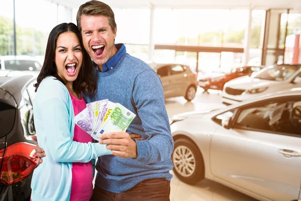 Casal segurando dinheiro — Fotografia de Stock