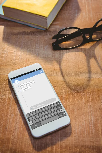 Smartphone and glasses on table — Stock Photo, Image