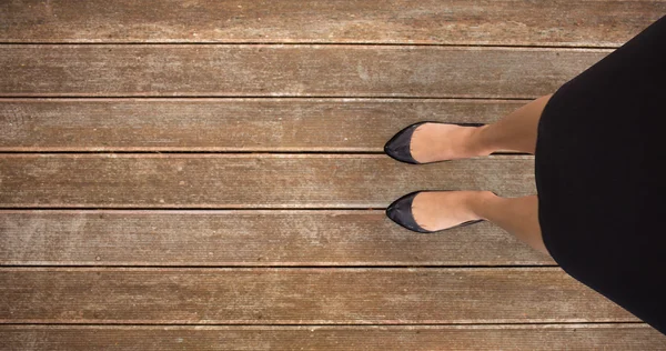 Businesswomans feet against wooden planks