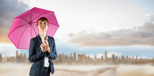 Businesswoman with umbrella against city — Stock Photo, Image