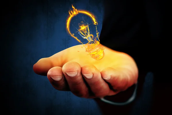 Hands out and light bulb in fire — Stock Photo, Image