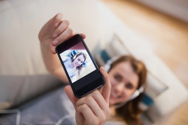 Mulher bonita deitada no sofá tomando selfie — Fotografia de Stock